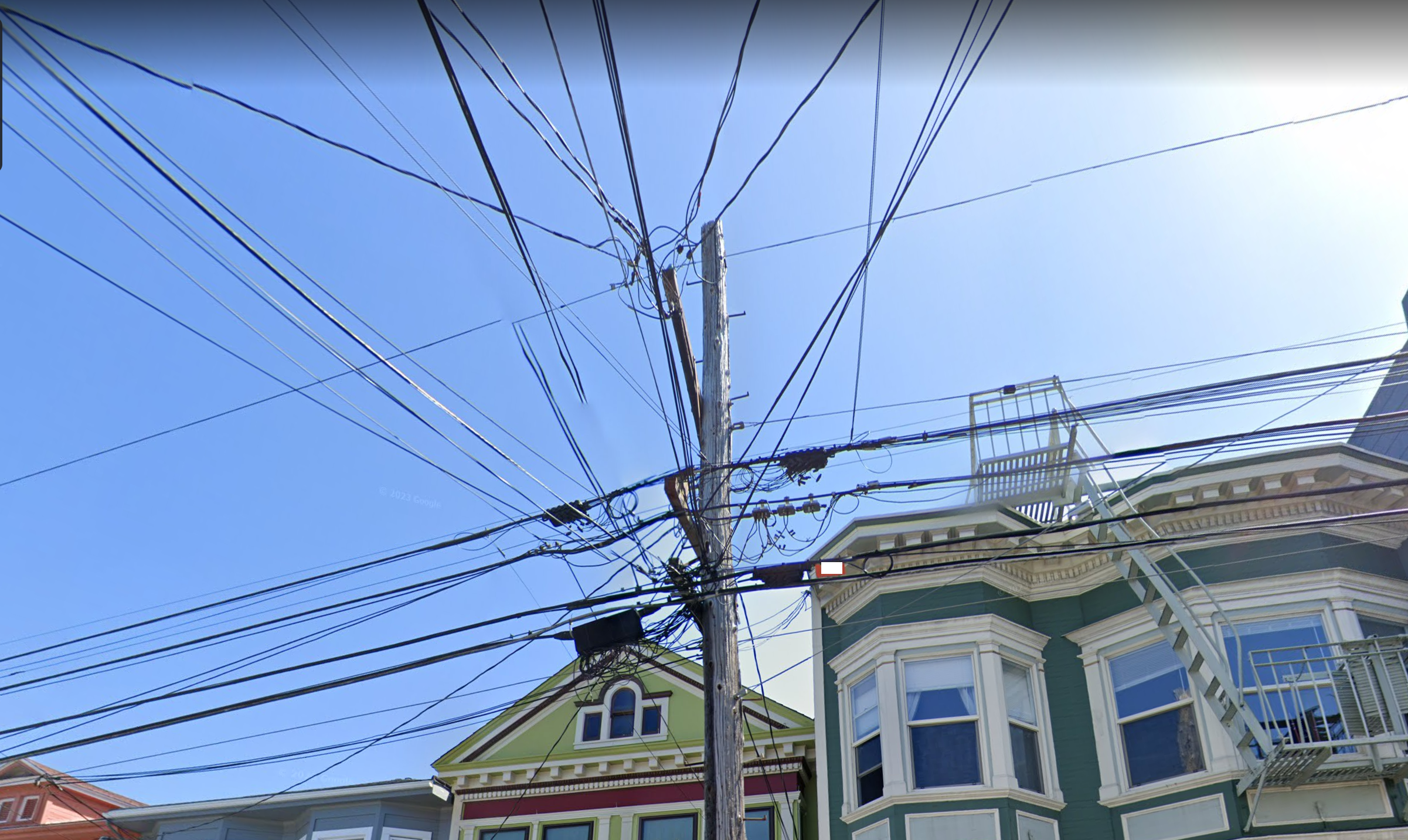 Photo of a utility pole with a mess of wires going in every direction